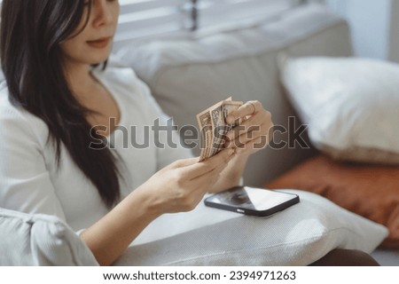 Close up photo of woman holding dollars and smartphone, online money transfer, web banking