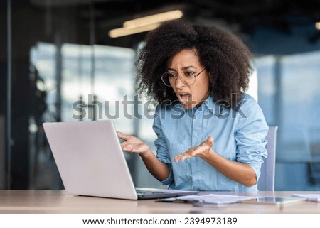 Woman at the workplace inside the office is not satisfied with the work of the computer, a frustrated businesswoman is shouting at a broken laptop, and overpriced broken software. Royalty-Free Stock Photo #2394973189