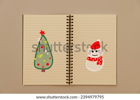 Draw a Christmas tree and a snowman by hand on a line notebook. to celebrate Christmas. Children, memories and charity.
