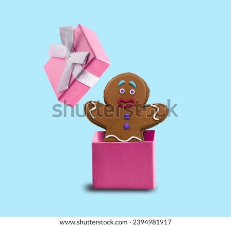 Ginger man jumps out of pink gift box on blue background. Minimal art postcard for winter holidays.