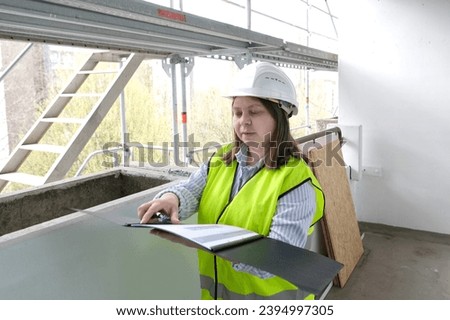 experienced woman architect, constructor engineer in protective white helmet controls the object at the construction site for the renovation of buildings, civil engineering concept Royalty-Free Stock Photo #2394997305