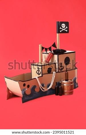 Pirate cardboard ship with explosive and bottles on red background