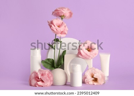 Composition with different cosmetic products, plaster podium and beautiful eustoma flowers on purple background Royalty-Free Stock Photo #2395012409