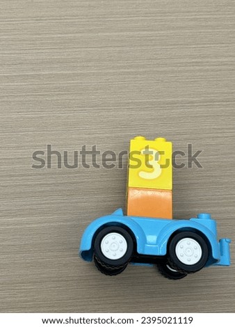 Blue car toy and yellow blocks on wooden table