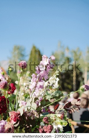 Beautiful high end wedding floral arrangement on the aisle for wedding ceremony with beautiful colorful pink, purple and white blossoms 