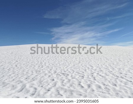 background of fluffy white freshly fallen snow on hill in mountains contrasting with blue sky in winter Royalty-Free Stock Photo #2395031605