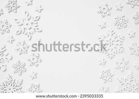 Festive border made of wooden snowflakes on white background. Winter, Christmas, New Year concept. Flat lay, top view, copy space.