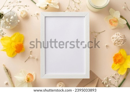 Embrace the beauty of spring holidays with daffodils and gypsophila. Above view photo features flower branches, envelope and candle on beige backdrop providing ample wooden frame for adverts or text