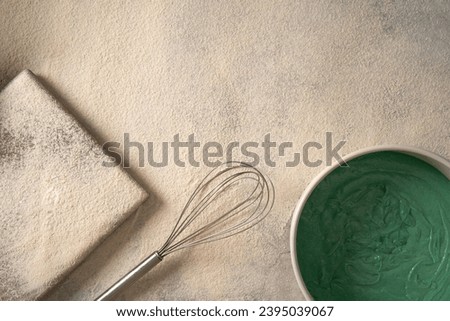 Baking background with flour, baking dish and green cream, top view. Flat lay.