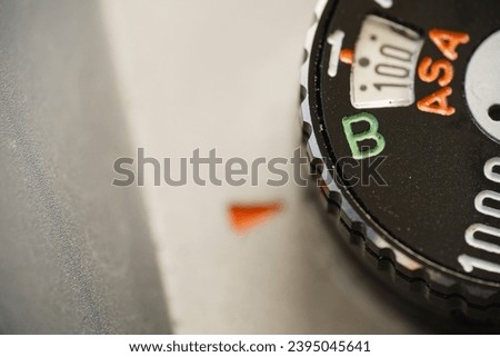 Shutter speed dial of an old film camera set to bulb mode, macro close up.