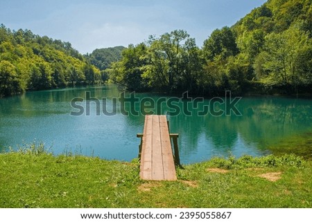 A wooden diving board on the River Una near Orasac, Bihac, in the Una National Park. Una-Sana Canton, Federation of Bosnia and Herzegovina. Early September Royalty-Free Stock Photo #2395055867