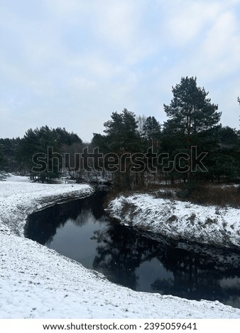 Winter picture: small river between the snowy banks. Cloudless sky background