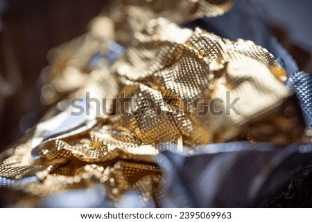 Enlarged view of gold foil candy wrappers. Wrinkled until the appearance of a rough surface.