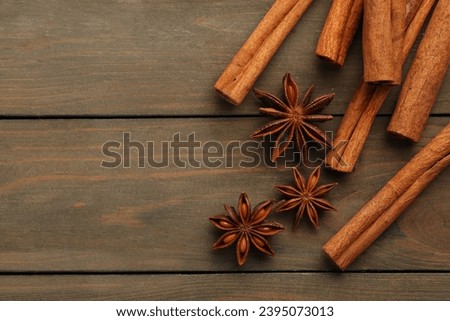 Cinnamon sticks and star anise on wooden table, flat lay. Space for text Royalty-Free Stock Photo #2395073013