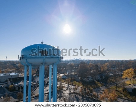 Upper Arlington water tower with a bear emblem, amid fall foliage and the Columbus, Ohio skyline. Royalty-Free Stock Photo #2395073095