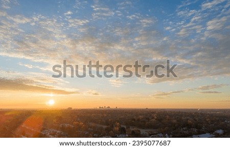 Golden sunrise over Columbus, Ohio, with scattered clouds and a clear view of the distant skyline.