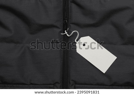 Coat with white blank tag on a string. Shopping, sale concept. Template for design