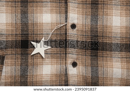 Checkered shirt with white blank tag on a string. Shopping, sale concept. Template for design
