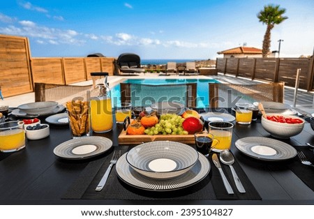 Poolside Culinary Delight: A captivating photo featuring a well-set table adorned with an array of vibrant fruits, coffee, juice, and snacks. Touch of resort-like ambiance, enhancing the overall sense