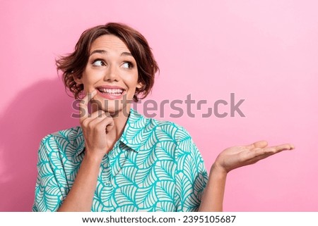 Portrait of nice cheerful lady finger touch chin toothy smile look hand demonstrate empty space isolated on pink color background
