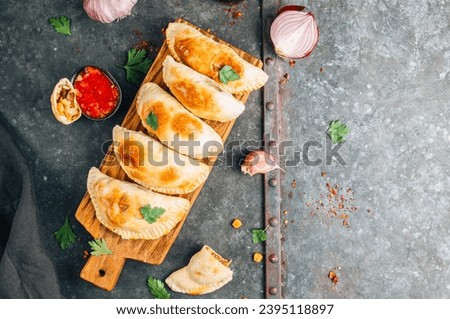 Baked Vegan Empanadas filled with a blend of potatoes, corn, and beans on a dark galvanized background. Top view Royalty-Free Stock Photo #2395118897