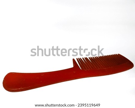 Red plastic hair comb, isolated on white background.