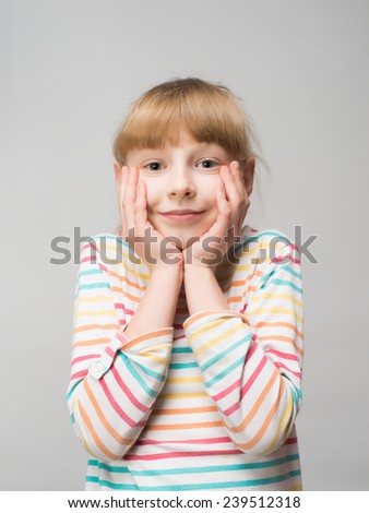 smiling little girl put hands on face