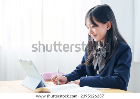 asian elementary school girl studying with tablet in classroom Royalty-Free Stock Photo #2395126237