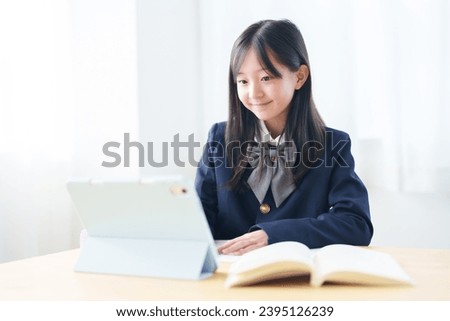 asian elementary school girl studying with tablet in classroom Royalty-Free Stock Photo #2395126239