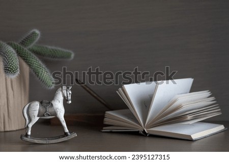 still life with open book, horse and cactus.