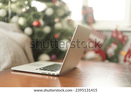 Wooden desk with computer with blank screen against blurred christmas lights background