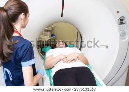 Pretty, young woman goiing through a Computerized Axial Tomography CAT Scan medical test examination in a modern hospital Royalty-Free Stock Photo #2395131569