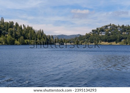View of the water, shoreline, and mountains at Lake Gregory Regional Park in Crestline, California