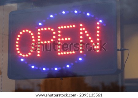 An illuminated sign announcing that the store is open