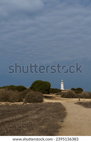 White lighthouse far away in cloudy weather