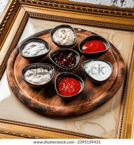 Set of sauces, mayonnaise, sauce, tomato sauce, berry spicy sauce, mustard, adjika, ketchup in bowls on pictures frame. Top view