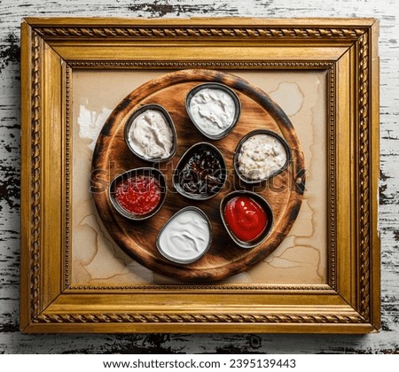 Set of sauces, mayonnaise, sauce, tomato sauce, berry spicy sauce, mustard, adjika, ketchup in bowls on pictures frame. Top view