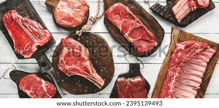 Set of various raw meat steaks. Fresh meat of beef, pork, veal, chicken, steak t-bone, rib eye, tomahawk, ribs, tenderloin on cutting board over white background. Meat food, butcher shop, top view Royalty-Free Stock Photo #2395139493