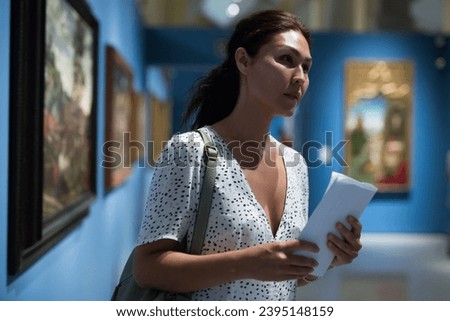 Middle aged woman walking through the gallery Royalty-Free Stock Photo #2395148159