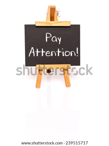 Pay attention. Blackboard with text and easel. Photo on white background with shadow and reflection.
