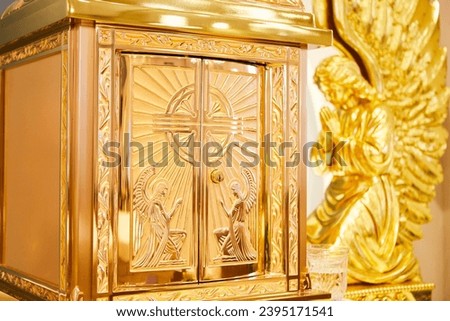Eucharist on an altar in a Catholic church with two golden angels on each side. Royalty-Free Stock Photo #2395171541