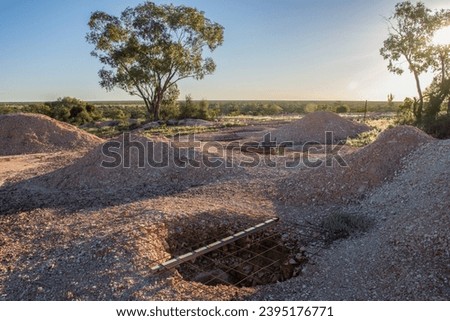 Abandoned mine entrances and damaged environment with rudimentary safety measures in Lightning Ridge, an opal mining town in New South Wales in Australia.