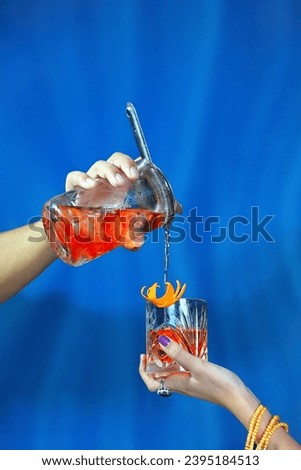 Pouring The Classic Negroni Cocktail into Glass Royalty-Free Stock Photo #2395184513