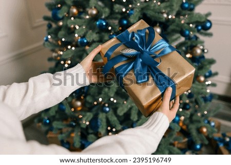 Gift box in the hands of mother and daughter, Christmas mood.