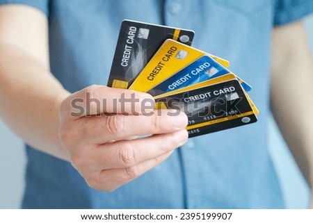 Man holding several credit cards and he is choosing a credit card to pay and spend Payment for goods via credit card. Finance and banking concept. Royalty-Free Stock Photo #2395199907