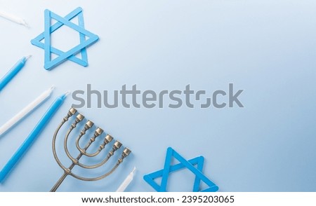 Jewish holiday Hanukkah concept. Top view of goldren menorah on pastel blue background. Royalty-Free Stock Photo #2395203065