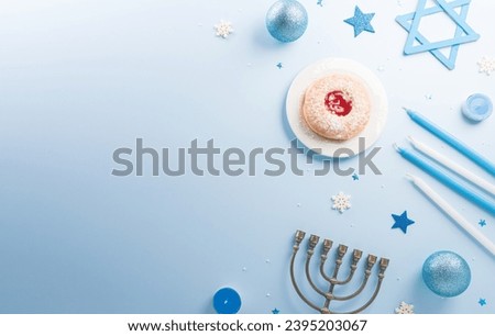 Jewish holiday Hanukkah concept. Top view of sweet donuts, menorah and candles on blue background.