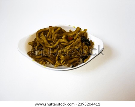 close-up Tumis Usus Ayam or Spicy Chicken Intestine on a white bowl isolated on a white background.  Indonesian Traditional Food. top view  