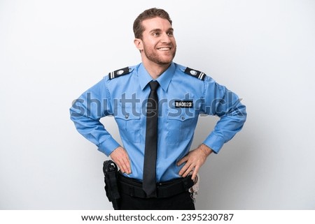Young police caucasian man isolated on white background posing with arms at hip and smiling