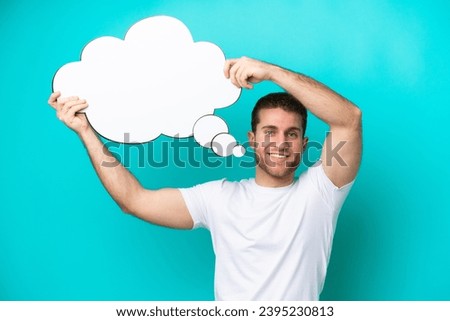Young caucasian man isolated on blue background holding a thinking speech bubble